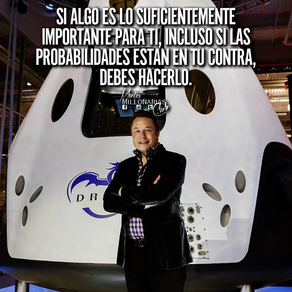 Se ve a Elon Musk de pie, con los brazos cruzados y mirando hacia la cámara con una leve sonrisa. Está vestido con una camisa negra y unos pantalones vaqueros. Detrás de él hay una nave espacial de SpaceX, la compañía aeroespacial que fundó.